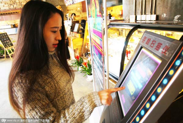 A customer scans her face in front of a machine in the hope of getting a free meal at a restaurant in Zhengzhou, Central China's Henan province, on Jan 11. [Photo/CFP]